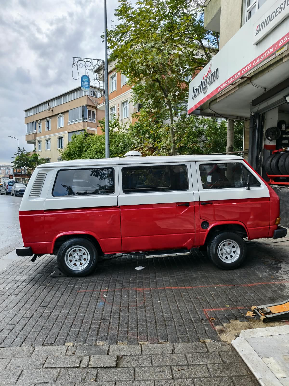 Şehirde park etmiş, kırmızı-beyaz Foto Bus karavanının gerçek görünümü
